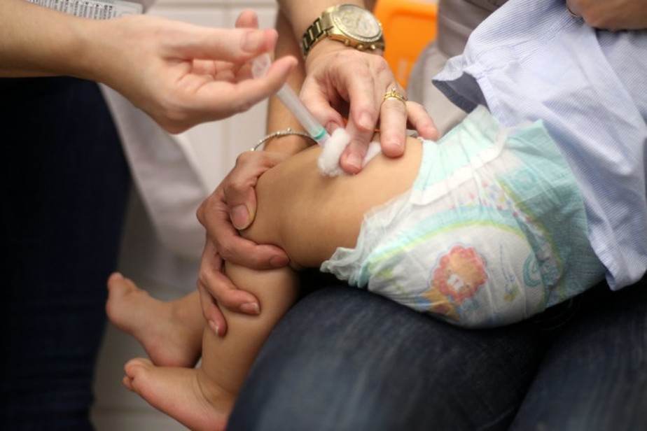 Um bebê recebe a vacina.