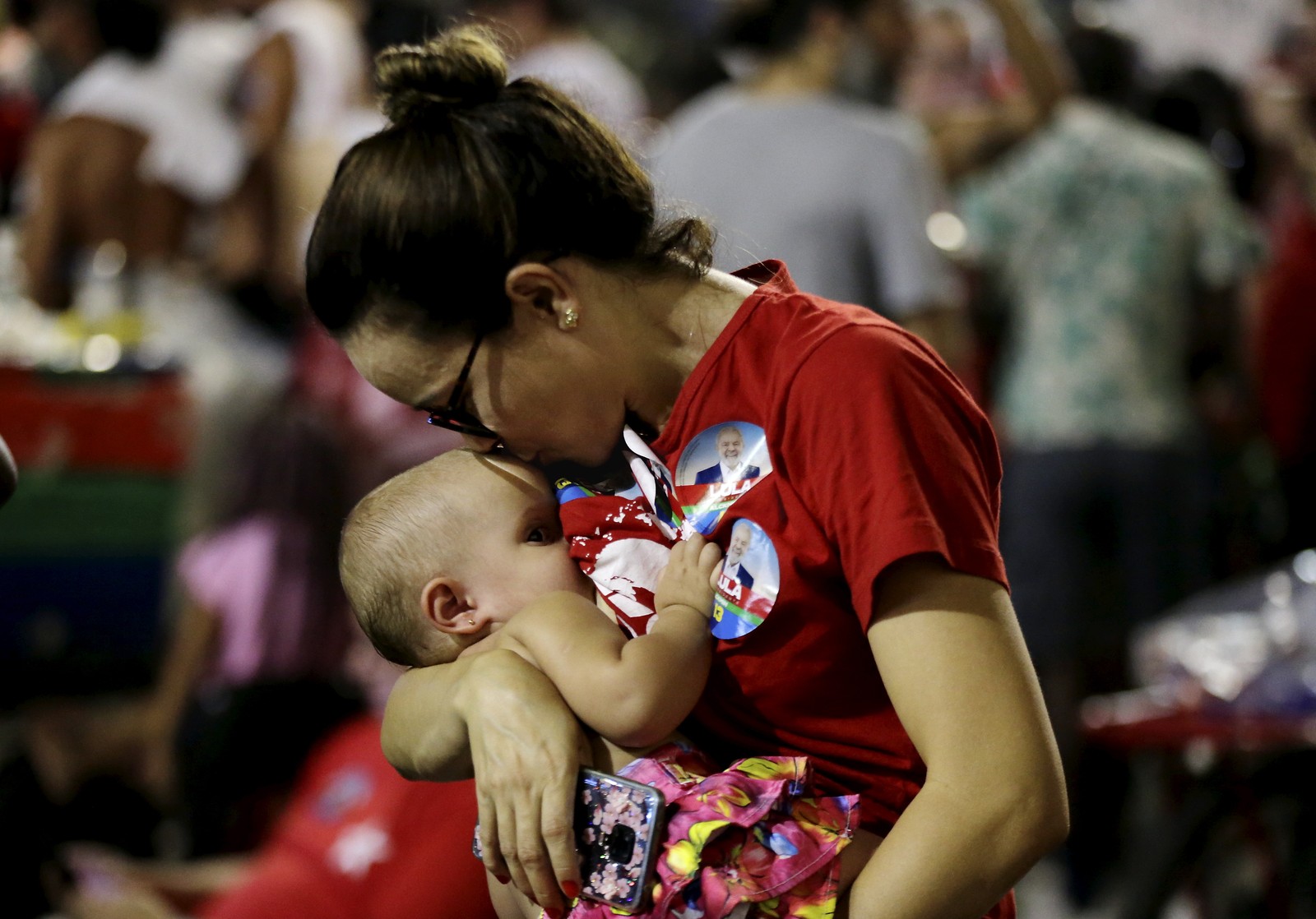 Mãe beija bebê enquanto acompanha resultado das eleições na Cinelância, Centro do Rio — Foto: Domingos Peixoto/Agência O Globo