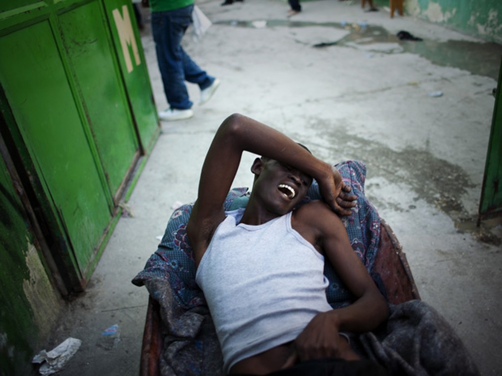 Haitiano com sintomas do cólera espera atendimento, em 2014,  em Porto Príncipe. (Foto: AP )