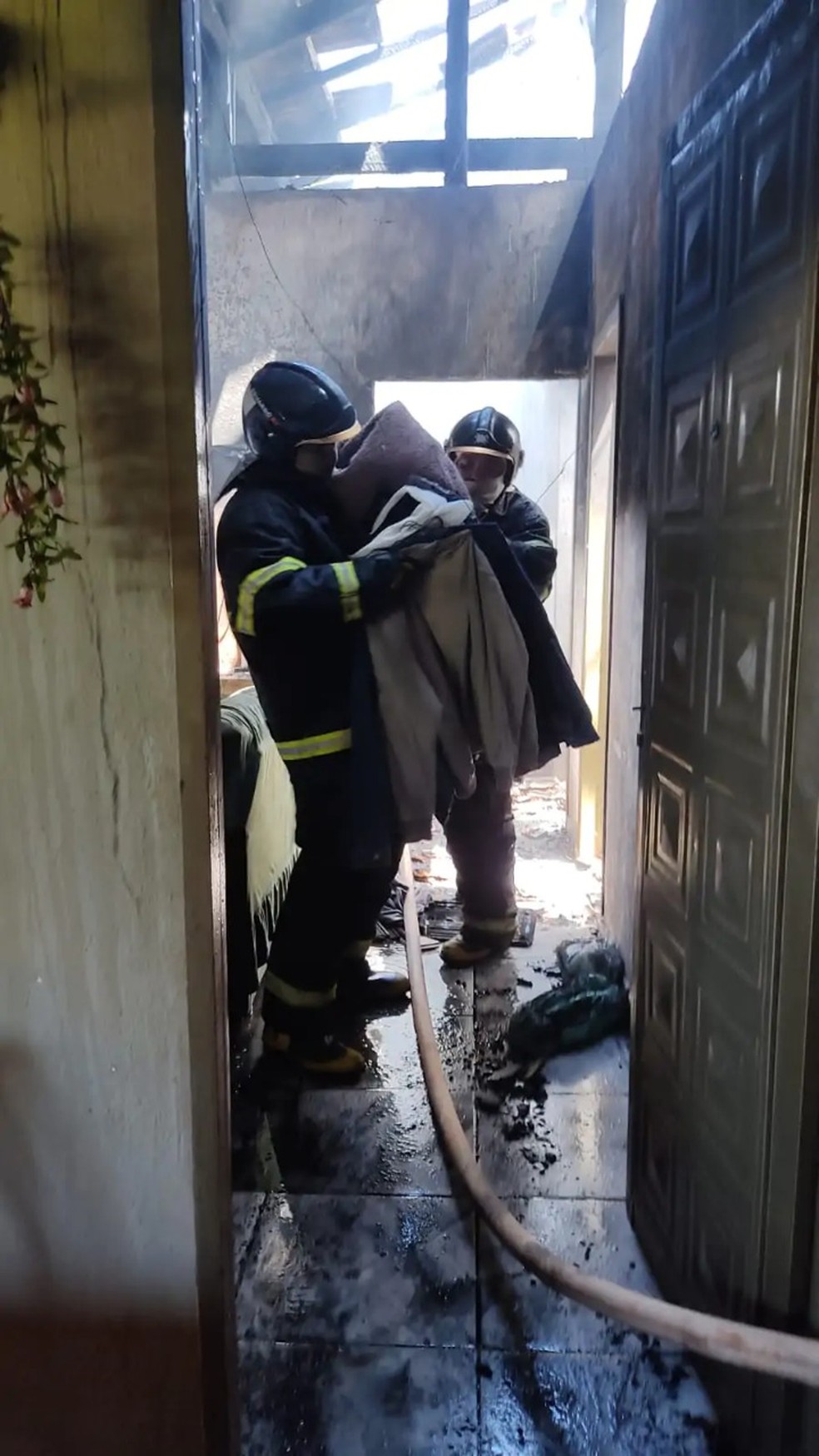 Bombeiros combatendo fogo na casa das vítimas. — Foto: Corpo de Bombeiros de Ivinhema