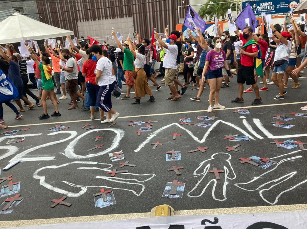 [João Pessoa, 03/07, 10h40] Manifestantes em João Pessoa espalharam fotos de vítimas da Covid-19.  — Foto: Lara Brito/G1 PB
