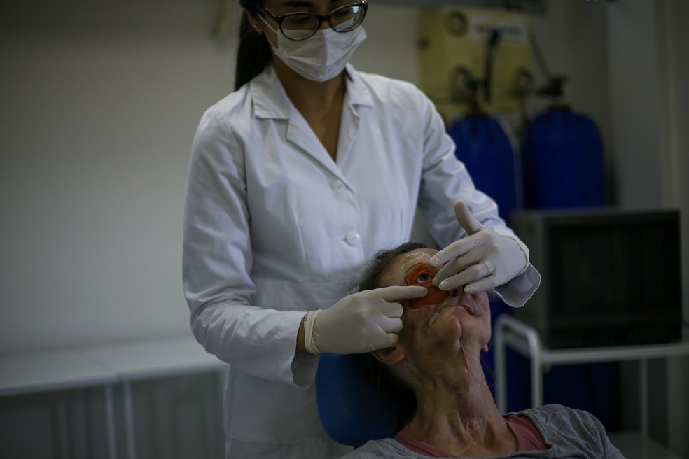 Paciente prova prótese de rosto impressa em impressora 3D — Foto: Miguel Schincariol/AFP