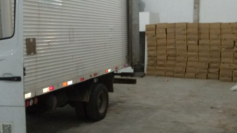 Caixas de cigarros contrabandeados foram localizados dentro de um galpão e próximo a um caminhão — Foto: Divulgação/Polícia Civil