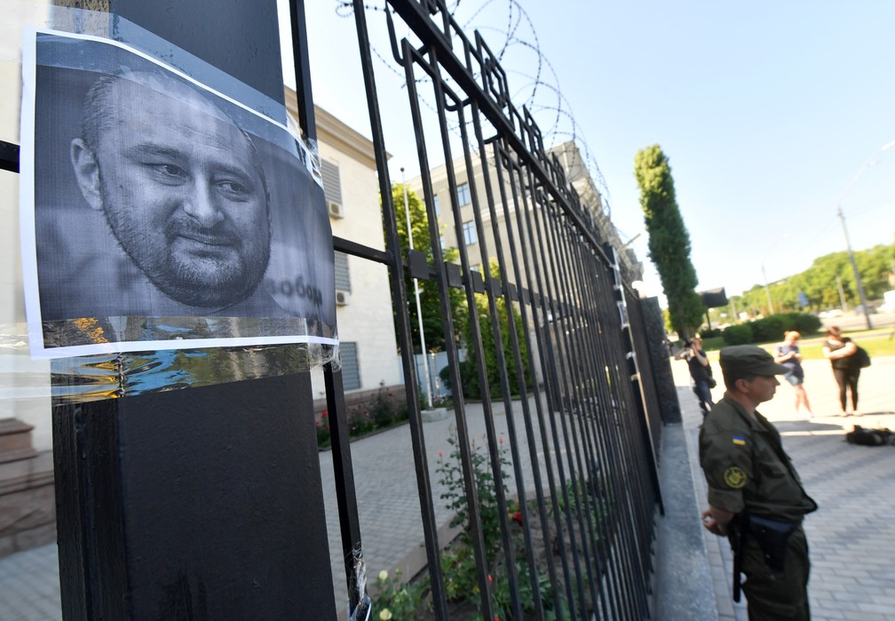 Poster com foto de Babchenko pendurado na Embaixada da Rússia em Kiev por ativistas, após a notícia falsa de sua morte (Foto: AFP/Sergei Supinsky)
