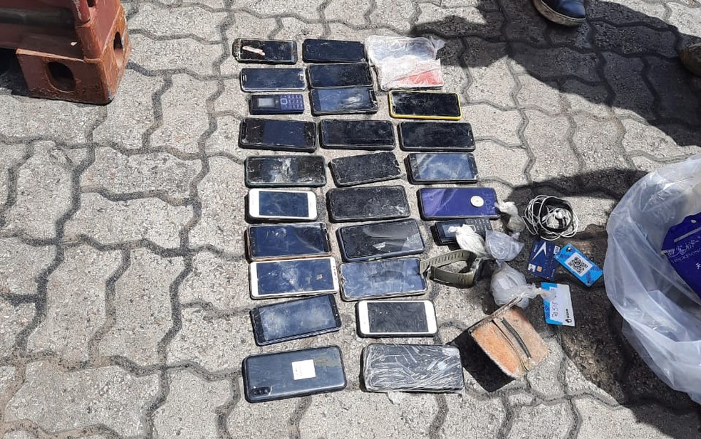 Vários aparelhos celulares foram encontrados ao lado dos corpos, que já estavam em estágio avançado de decomposição — Foto: Polícia Federal/Divulgação