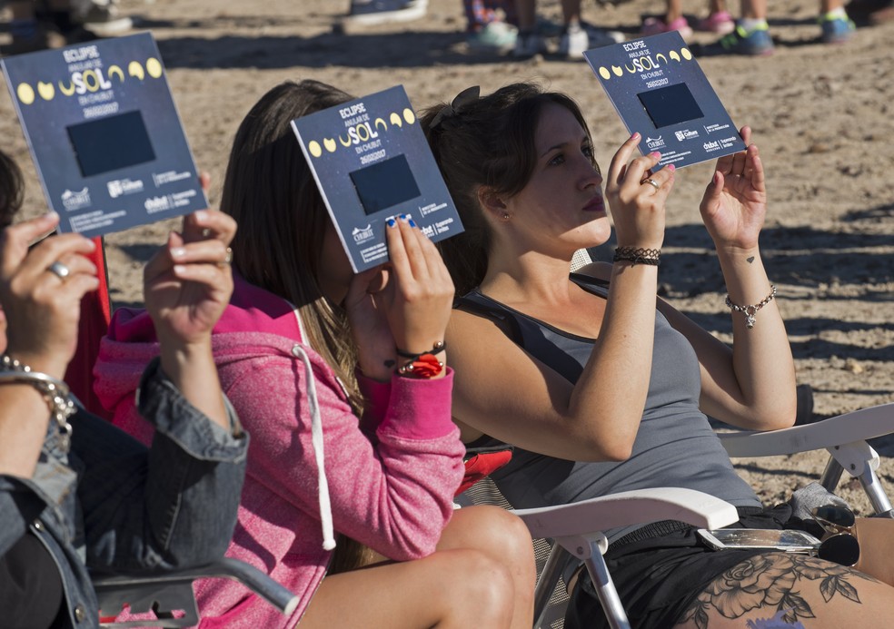 Pessoas se preparam para observar o esclipse solar deste domingo (26) na província de Chubut, Argentina (Foto: ALEJANDRO PAGNI / AFP)