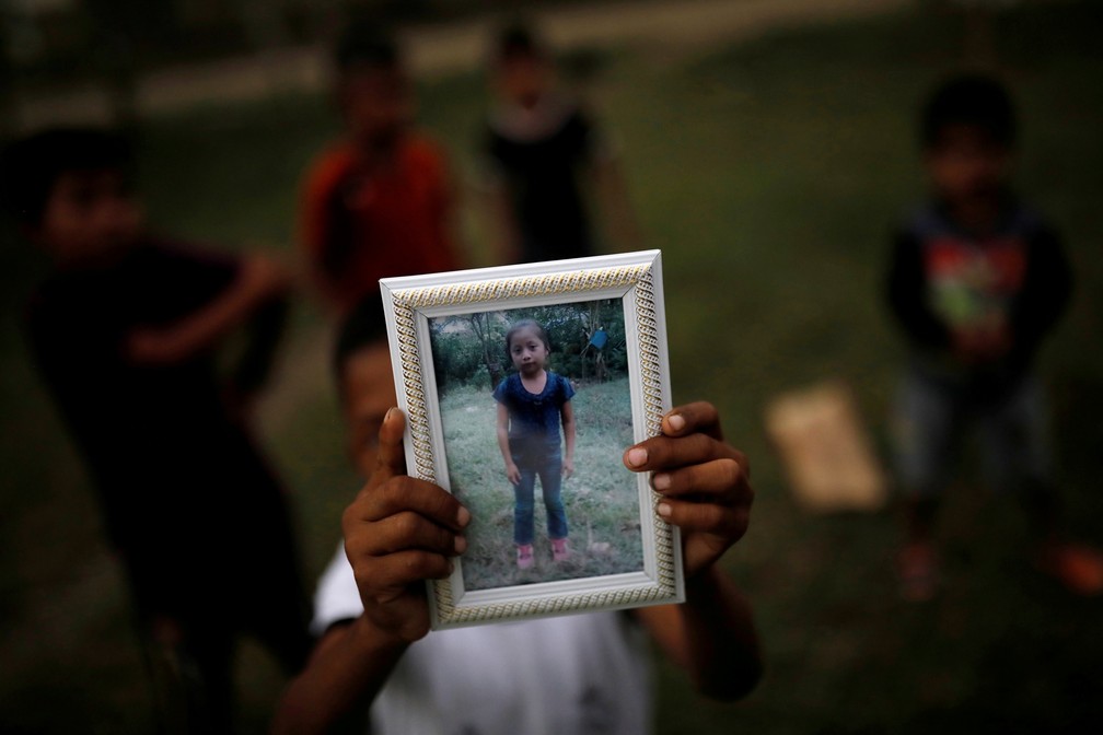 IrmÃ£o segura foto da menina Jakelin Caal, que morreu nos EUA â Foto: Carlos Barria/Reuters