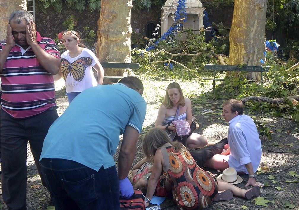 Pessoa ferida em queda de árvore na ilha da Madeira é atendida no local nesta terça-feira (15) (Foto: ASPRESS via AP)