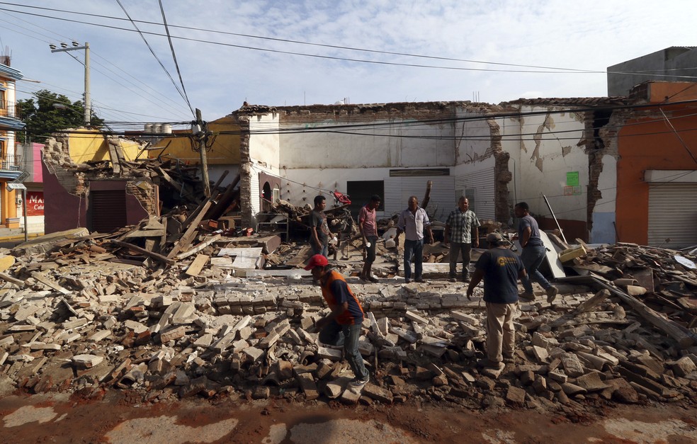 Pessoas são vistas em volta dos escombros de um edifício após terremoto, em Oaxaca, no México (Foto: Luis Alberto Cruz/AP)