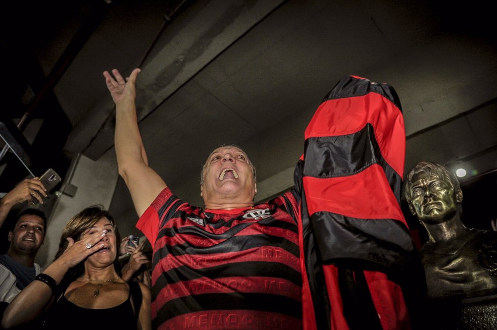 Leandro de camisa e bandeira do Flamengo ao lado do seu busto &mdash; Foto: Flamengo / Divulga&ccedil;&atilde;o