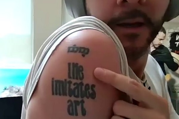 O ator Dominic Monaghan mostrando a tatuagem feita por ele com seus amigos de elenco na trilogia O Senhor dos Anéis (Foto: YouTube)