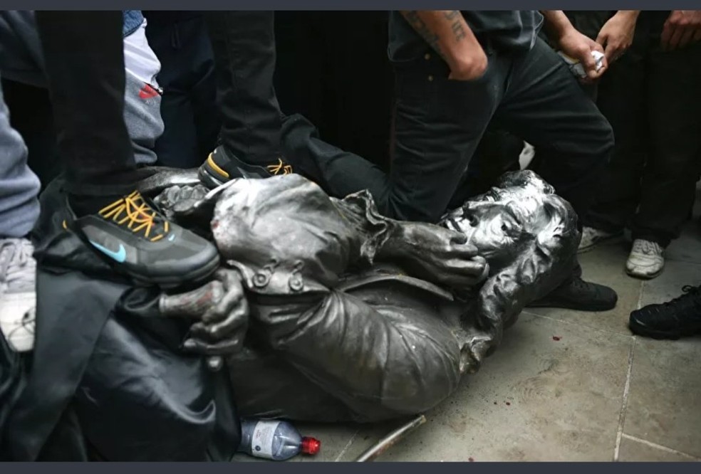 Manifestantes derrubam estátua de mercados de escravos — Foto: Reprodução