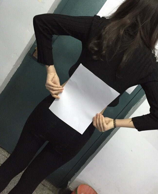Menina mede sua cintura usando uma folha A4 como medida (Foto: Reprodução/Twitter)