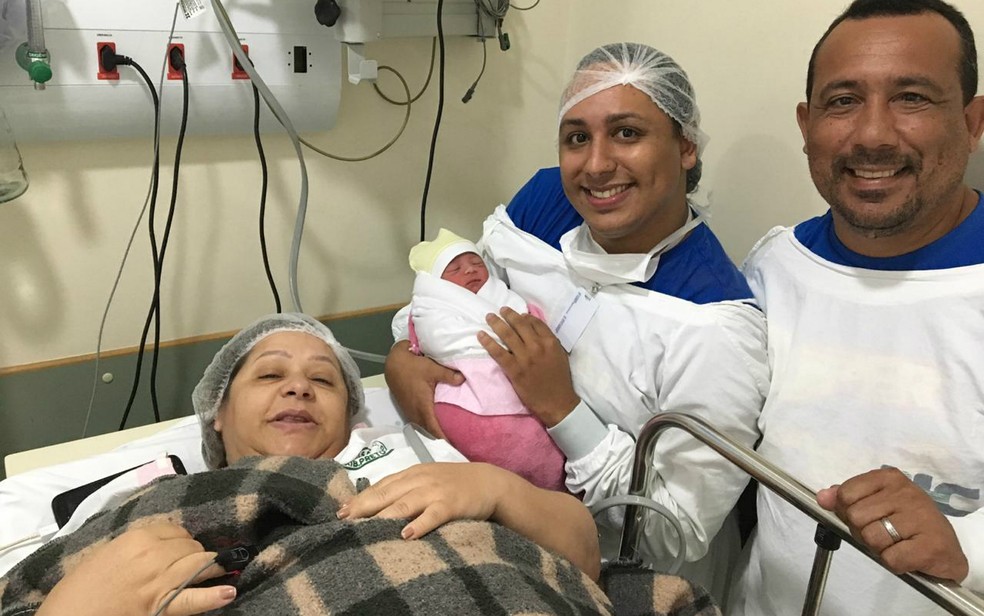 Marcelo das Neves Junior, de 24 anos, segura um dos filhos ao lado da mãe e do pai — Foto: Arquivo Pessoal