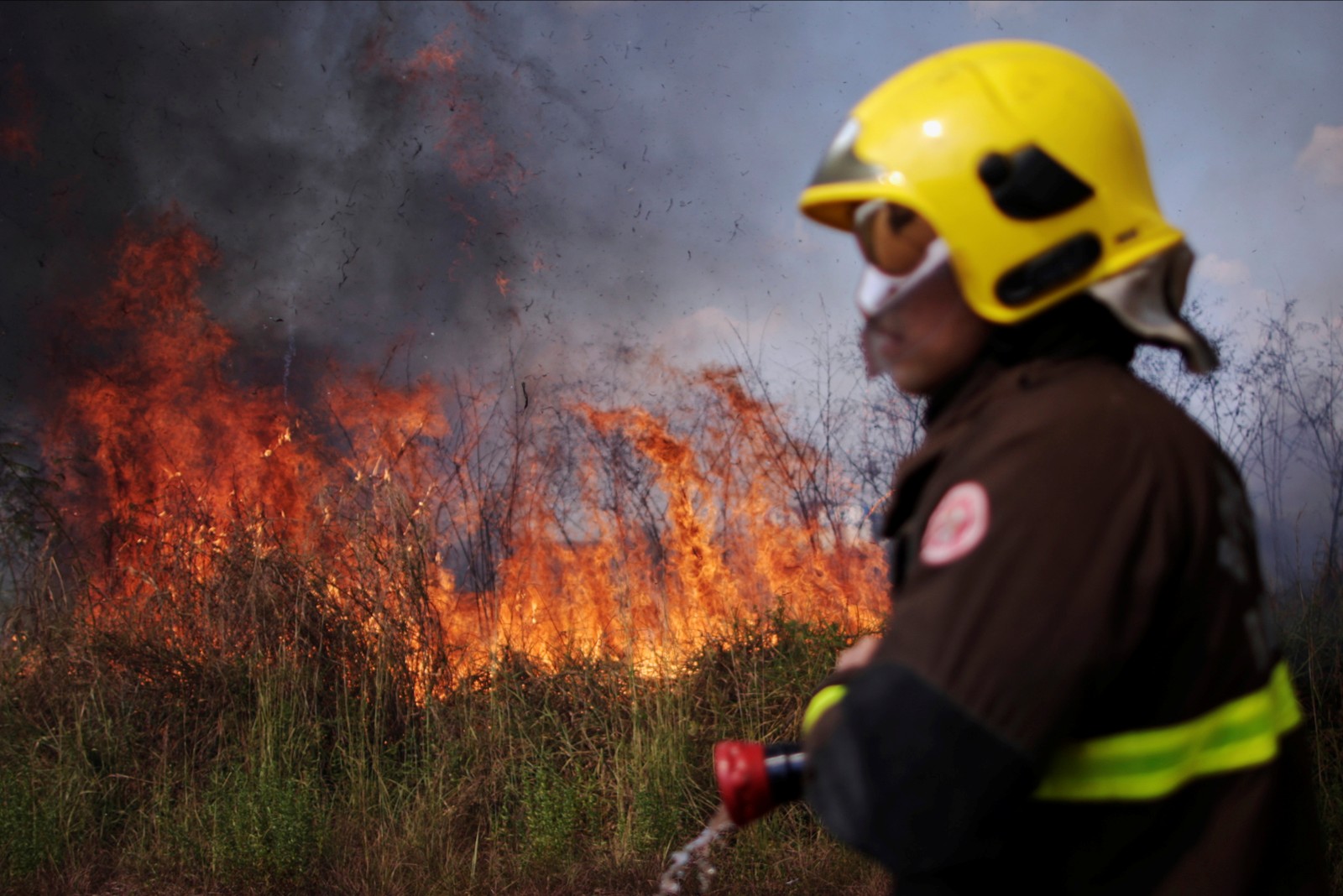 Moradores e bombeiros no noroeste do Brasil estão lutando contra os incêndios que assolam a Amazônia, destruindo terras agrícolas e ameaçando suas casas, em Porto VelhoREUTERS