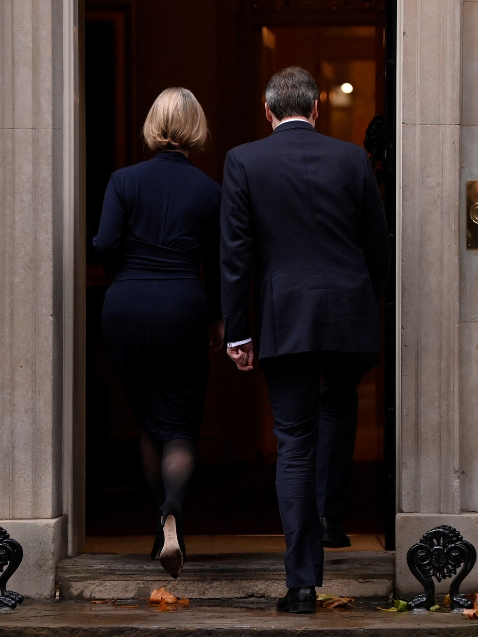 A primeira-ministra britânica, Liz Truss, acompanhada de seu marido após anunciar renúncia do cargo, em 20 de outubro de 2022.  — Foto: Toby Melville/ Reuters 