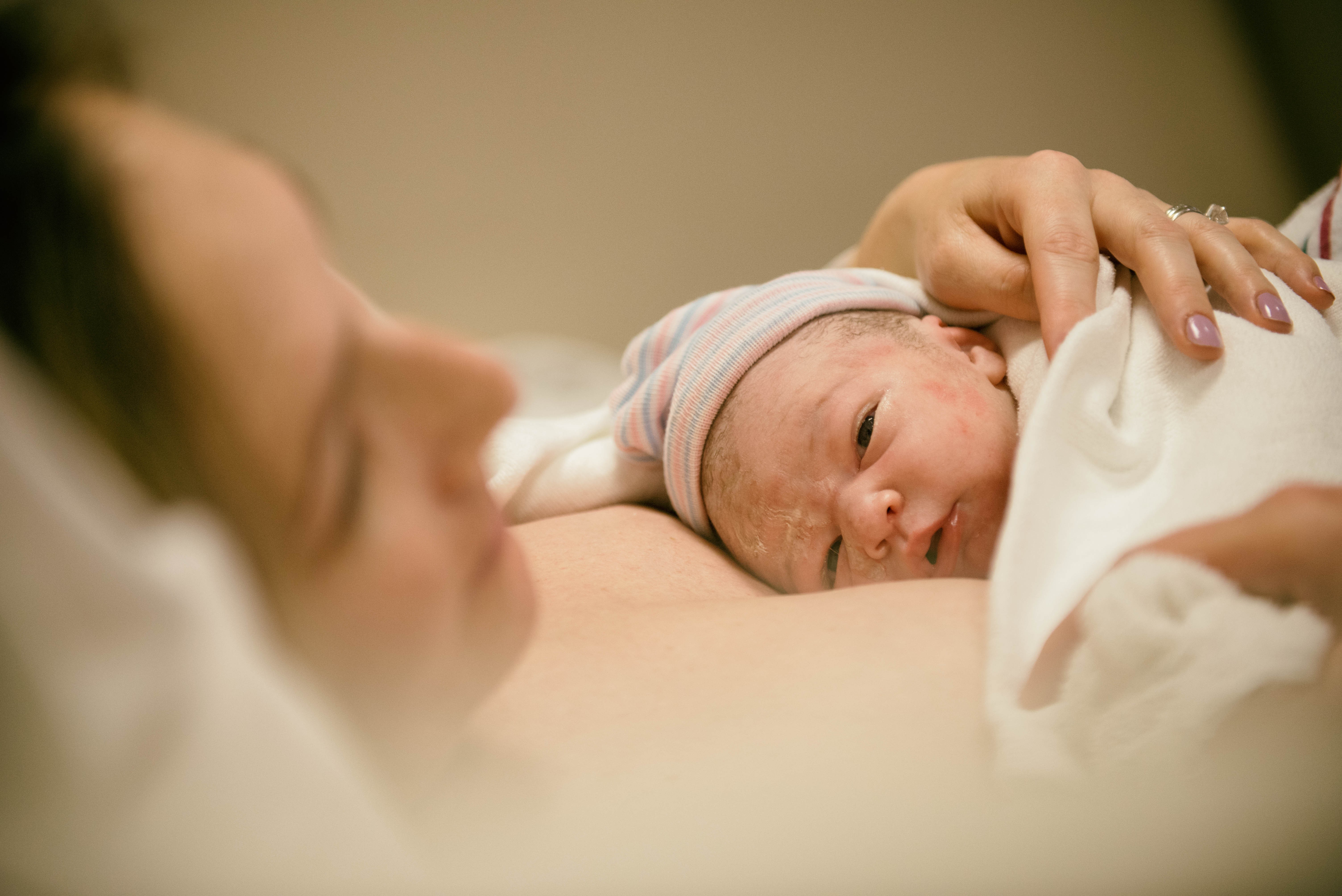 Mãe com recém-nascido no colo depois de parto normal hospitalar (Foto: Getty Images)