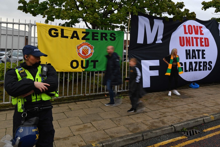 Manifestantes penduram faixas do lado de fora do estádio Old Trafford para protestar contra os donos do Manchester United antes da partida contra o Liverpool em Old Trafford em 22 de agosto de 2022