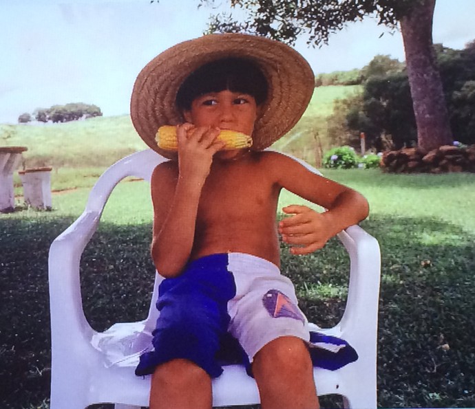 Tiago Iorc se delicia com espiga de milho na infância (Foto: Arquivo Pessoal)