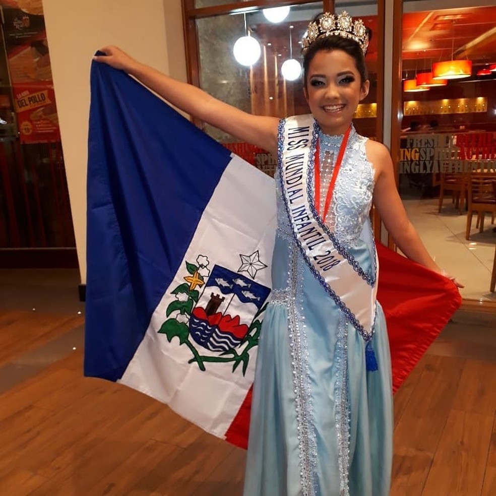No Peru, Júlia Titara posa com a bandeira de Alagoas após conquistar o título de Miss Mundial Infantil 2018 — Foto: Júlia Titara/Arquivo pessoal