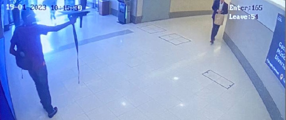 Um dos criminosos aponta metralhadora para clientes e funcionários dentro do Shopping Tamboré, em Barueri, durante assalto a loja de celulares — Foto: Reprodução/Câmera de segurança