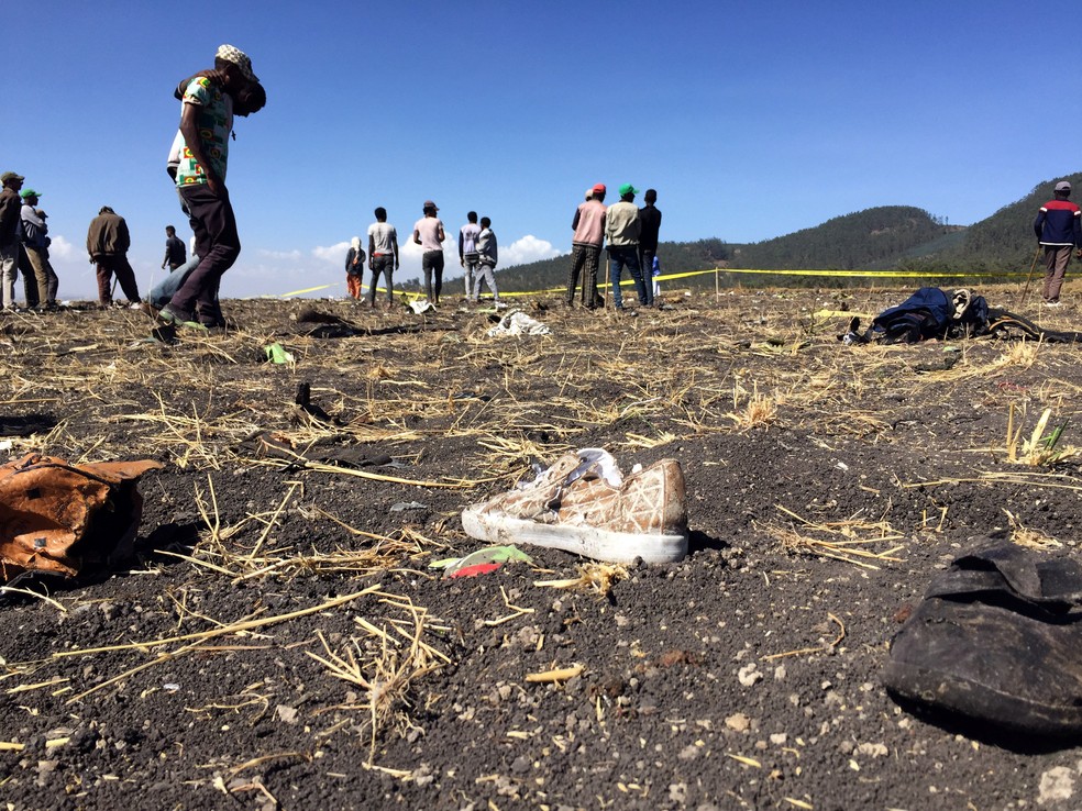 Pessoas caminham sobre o local de acidente aéreo na Etiópia — Foto: Tiksa Negeri/Reuters