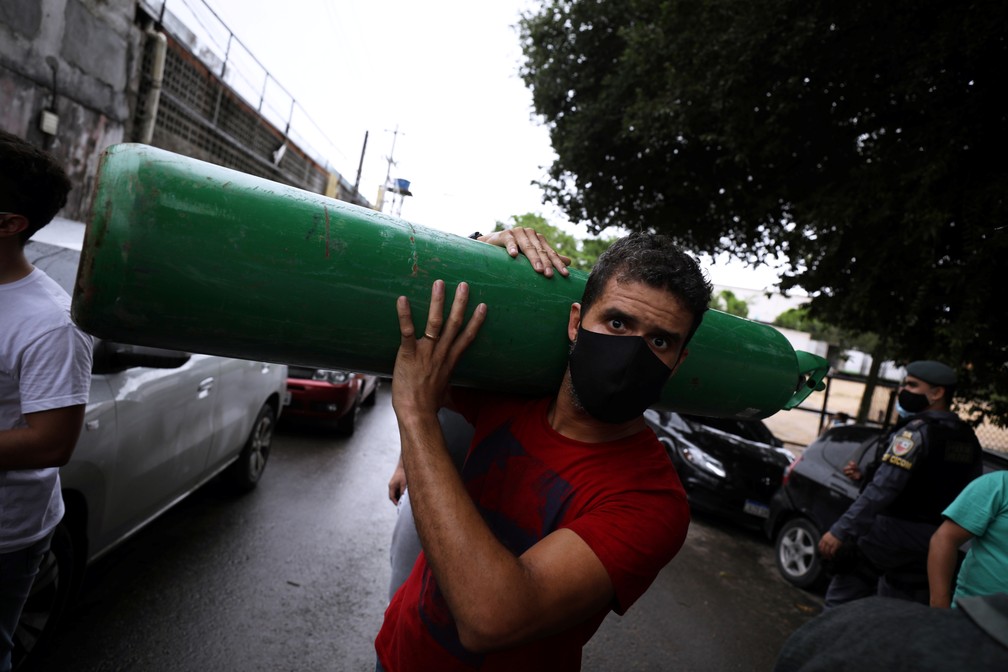 15 de janeiro - Homem carrega cilindro para tentar socorrer pacientes com Covid-19 em Manaus, no Amazonas — Foto: Bruno Kelly/Reuters