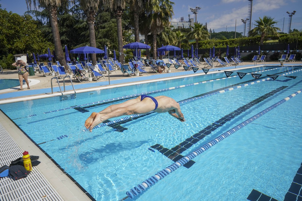 Um homem mergulha em uma piscina ao ar livre no centro esportivo Forum em Roma, na Itália, durante sua reabertura após mais de dois meses de fechamento para evitar a propagação do coronavírus — Foto: Andrew Medichini/AP