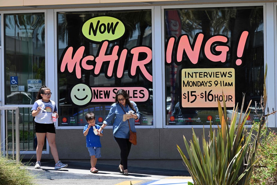 Família passa por uma placa de 'contratação' em restaurante do McDonald's em Garden Grove, Califórnia