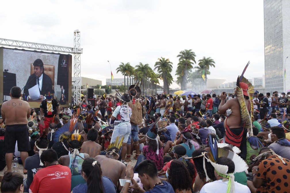 Indígenas acompanham em telão, do lado de fora do STF, julgamento sobre marco temporal para demarcação de terras — Foto: Mariana Alves/Futura Press/Estadão Conteúdo