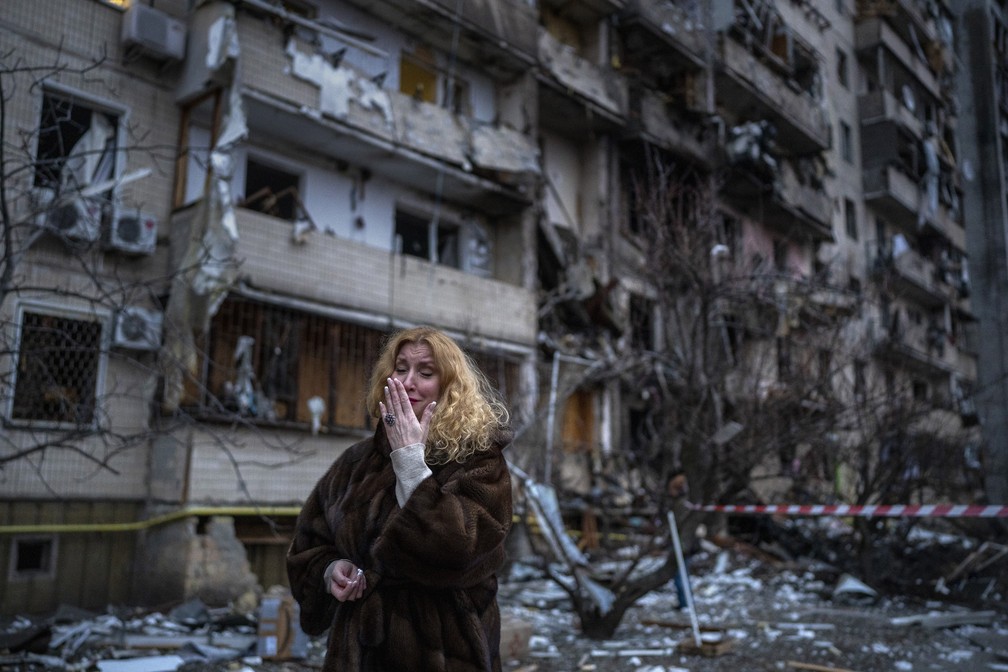 25 de fevereiro - Natali Sevriukova chora em frente ao prdio onde morava aps um ataque com foguete em Kiev, na Ucrnia — Foto: Emilio Morenatti/AP