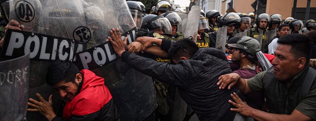 Pessoas entram em confronto com a tropa de choque durante uma manifestação exigindo a libertação do ex-presidente Pedro Castillo e o fechamento do Congresso peruano, em Lima — Foto: ERNESTO BENAVIDES/AFP
