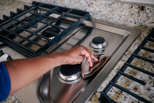 Close-up of unrecognizable black woman wiping cooktop (Foto: Getty Images)