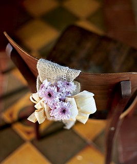 Roça chique: palha de milho, flores do campo e juta decoram o encosto da cadeira