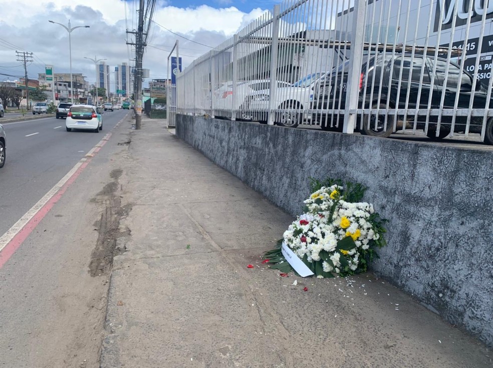 Família da idosa deixa buquê de flores no local onde ela foi baleada na Avenida Barros Reis — Foto: Nicolle Schiller/TV Bahia