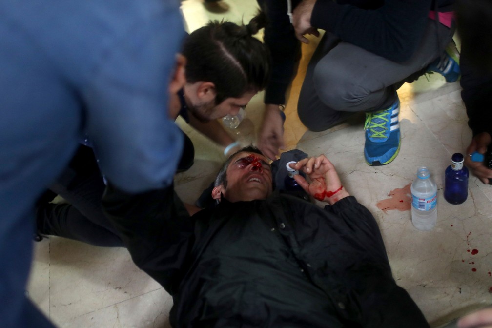 Manifestante é ferido por bala de borracha atirada pela polícia espanhola perto da escola Ramon Llull, em Barcelona (Foto: Manu Brabo/AP)