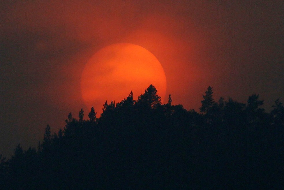 O sol se põe por trás de uma floresta da taiga siberiana no horizonte em Krasnoyarsk, na Rússia — Foto: Ilya Naymushin/Reuters