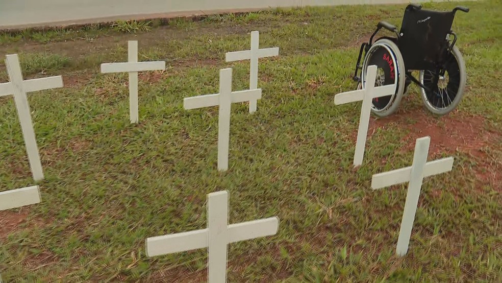 Cruzes e cadeira de rodas representando vítimas de atropelamentos em rodovias, em campanha de conscientização da PRF — Foto: TV Globo/Reprodução
