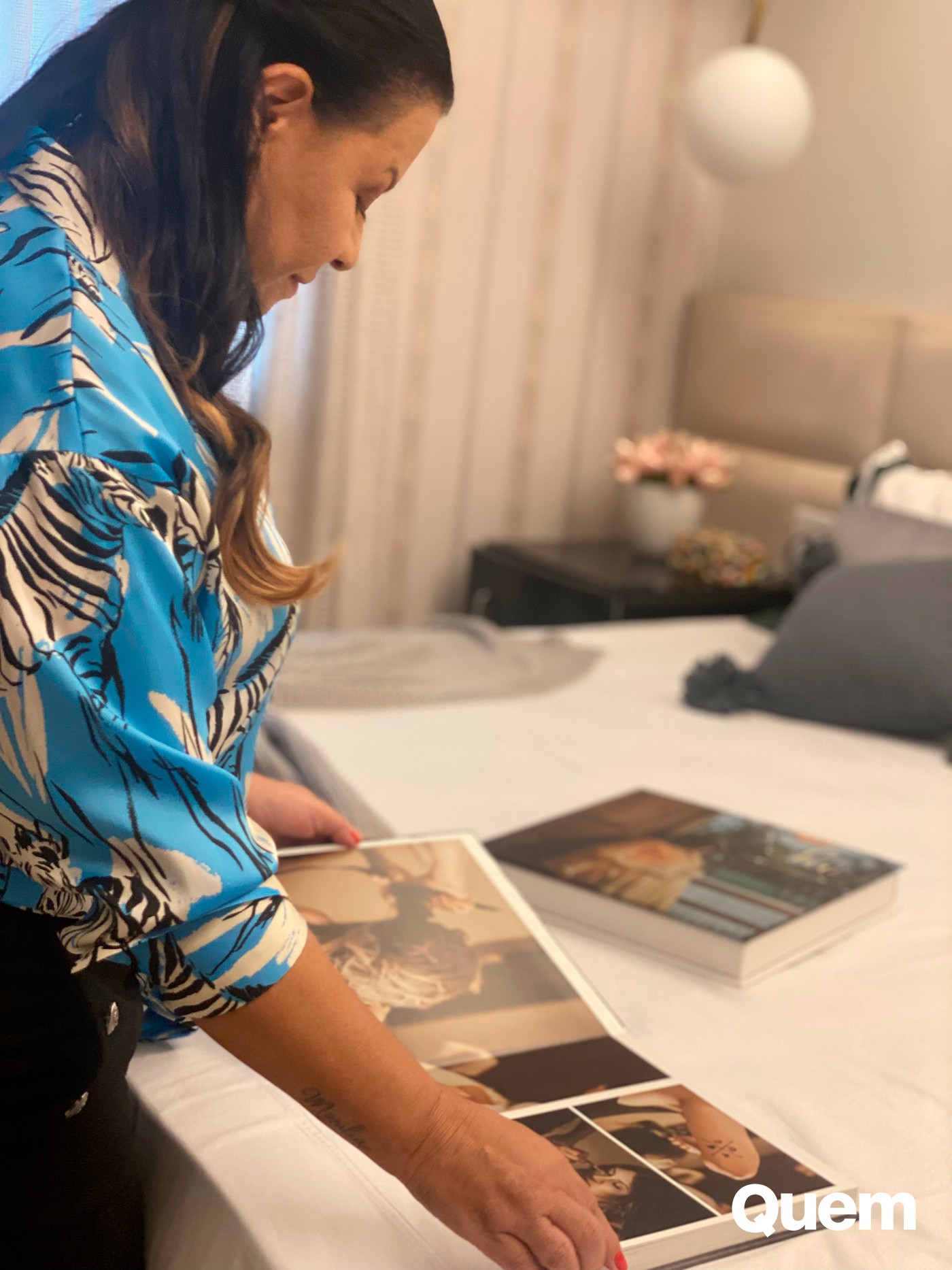 Dona Ruth mostra álbum de fotos de Marilia Mendonça — Foto: QUEM/Rosi Campos