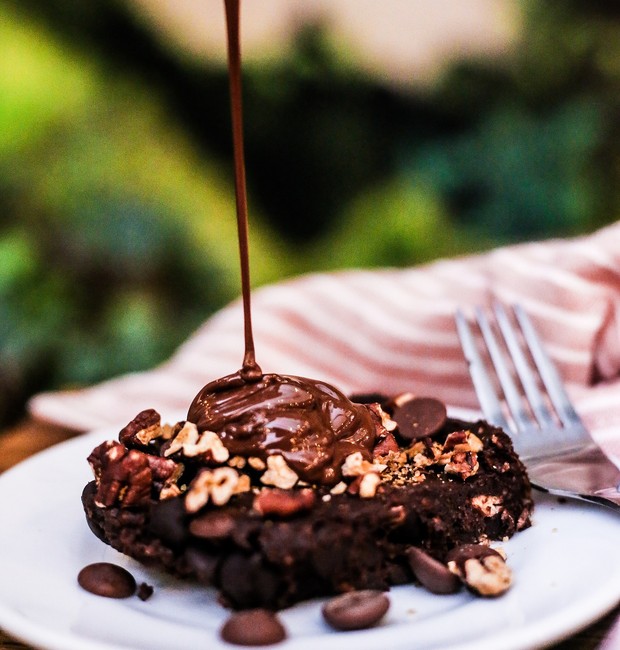 Finalize o brownie vegano com calda de chocolate amargo, gotas de chocolate, nozes-pecã e flor de sal (Foto: Julia Guedes / Divulgação)