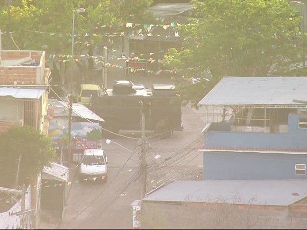 Policiais militares desembarcam de blindado no alto do Morro da Serrinha (Foto: Reprodução / TV Globo)