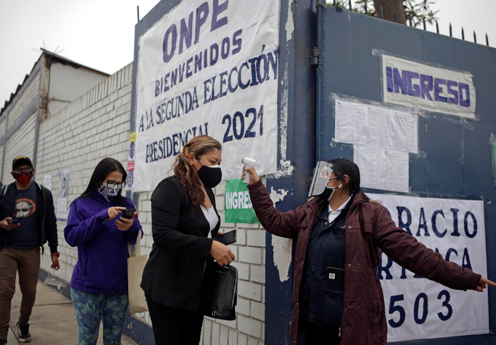 Pessoas chegam a uma seção eleitoral para votar no segundo turno da eleição presidencial em Lima, Peru. — Foto:  REUTERS / Liz Tasa