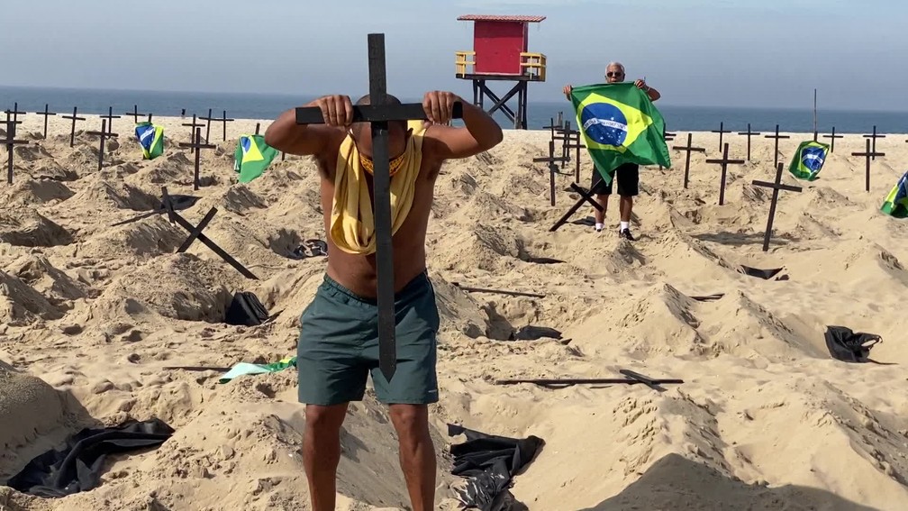 Pai de um jovem que morreu de Covid-19 recoloca cruz na areia retirada por homem contrário ao protesto organizado pela ONG Rio de Paz — Foto: Reprodução