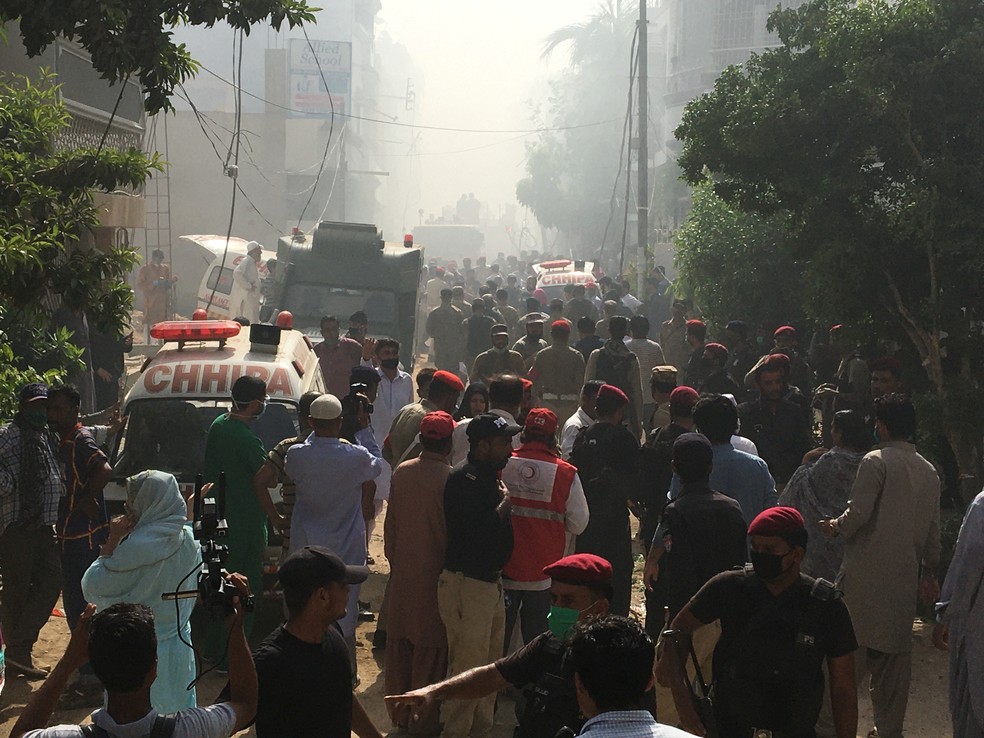 Ambulâncias e carros de bombeiros perto de local onde um avião comercial caiu com 107 pessoas a bordo em área residencial perto do aeroporto de Karachi, no Paquistão — Foto: Akhtar Soomro/Reuters