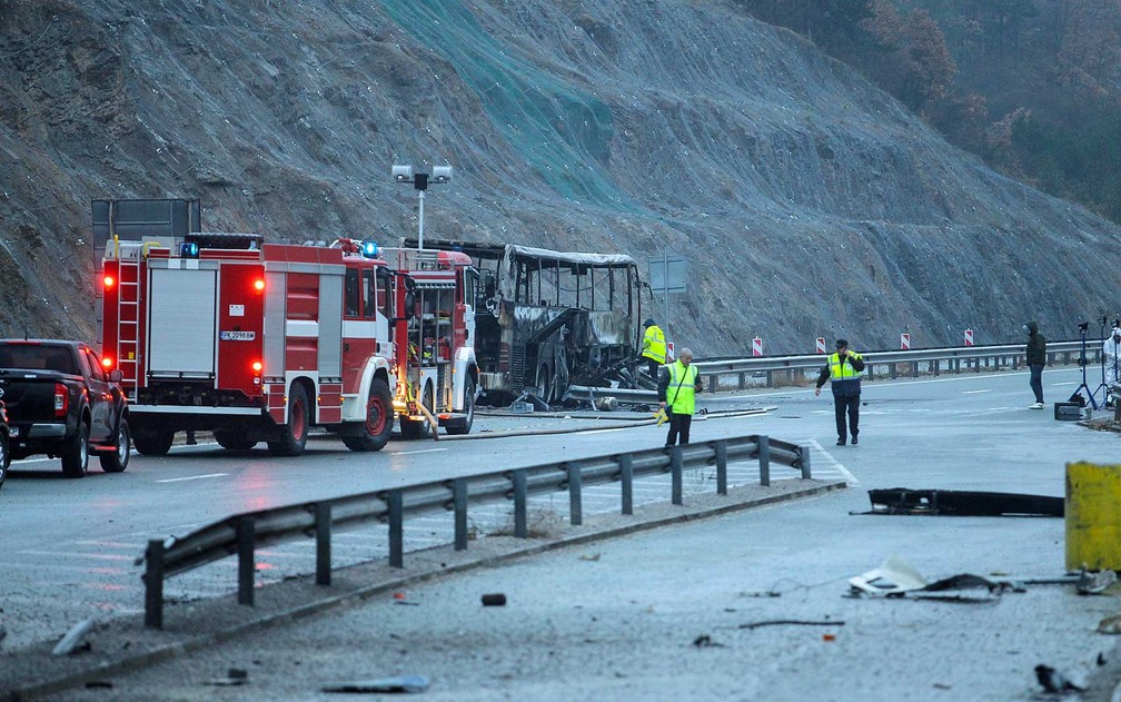 Funcionários trabalham no local do acidente de ônibus na Bulgária em que 45 pessoas morreram. Tragédia ocorreu em rodovia próxima ao vilarejo de Bosnek, ao sul da capital Sófia — Foto: Dimitar Kyosemarliev/AFP