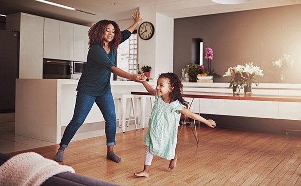 Shot of a little girl and her mother dancing at home (Foto: Getty Images)