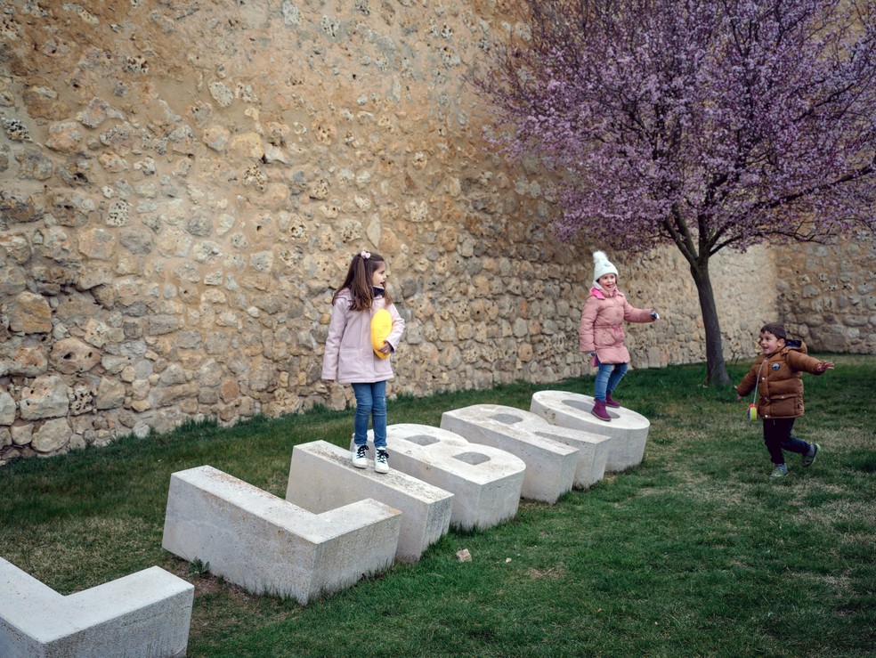 Crianças brincam no letreiro que descreve Urueña como a 'cidade do livro' na Espanha — Foto: Samuel Aranda/The New York Times