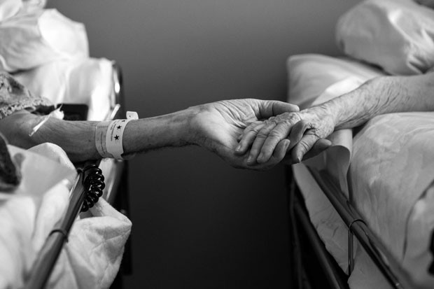 Don e Maxine Simpson são vistos de mãos dadas em camas de hospital em julho de 2014. Eles morreram com apenas quatro horas de diferença após 62 anos de casamento (Foto: Melissa Sloan/AP)