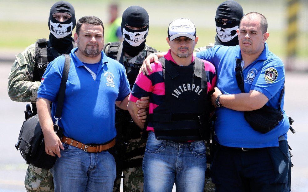 O ex-prefeito paraguaio Vilmar 'Neneco' Acosta é escoltado pela polícia em sua chegada ao aeroporto de Assunção, no Paraguai — Foto: Jorge Saenz/AP
