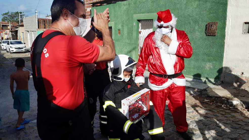 Garoto recebe visita do Papai Noel e realiza sonho de andar em caminhão-tanque do Corpo de Bombeiros em Natal — Foto: Sérgio Henrique Santos/Inter TV Cabugi